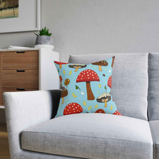 Organic Mushroom Throw Pillow with red and brown toadstool design on bright blue background on a gray sofa