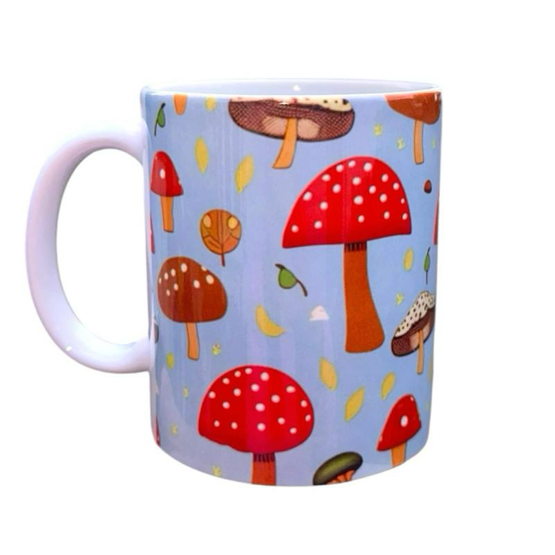 ASKMOLSH ceramic mug with a whimsical mushroom pattern in red, brown, and blue, featuring falling leaves and celestial accents.